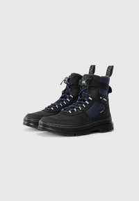Bottes de randonnée noires et bleu marine avec un design montante, comportant des lacets, une semelle en caoutchouc épaisse, et des accents renforcés pour la durabilité.