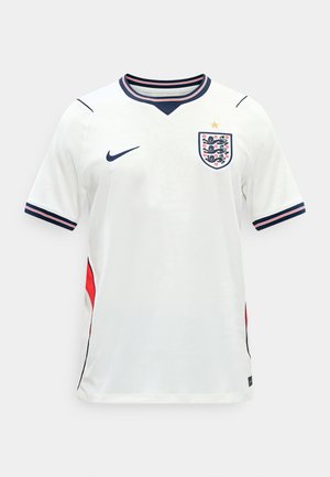 Bela angleška nogometna majica kratkih rokavov z mornarsko modrimi in rdečimi obrobami, z grbom Treh levov in zlatim zvezdico nad njim.