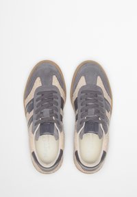 Baskets en daim gris et en peau lainée beige avec des bandes gris foncé et des lacets assortis. Semelle en caoutchouc, logo sur la languette et semelle intérieure rembourrée.