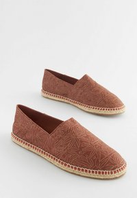 Hnedé espadrilky so vzorom listov, textilný zvršok a podrážka z juty s bielym prešívaním pozdĺž okraja.