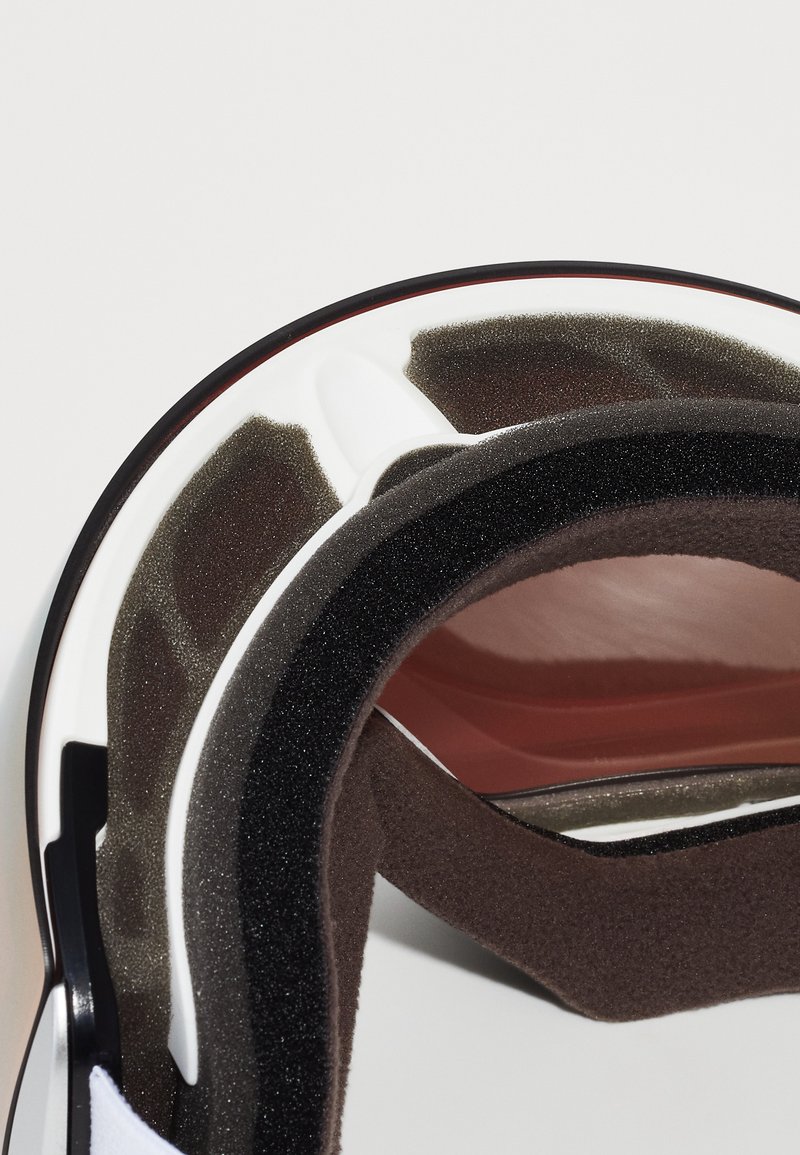 Skihalemminnen mit schwarzem und grauem Schaumstoffpolster, weißem Außenschalen, roten Akzenten und glatter Textur; konzipiert für Komfort und Sicherheit.