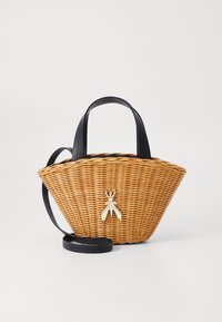 Woven ratanová kabelka v širokém kuželovém tvaru s černými koženými ušima a dekorativním kovovým hmyzem na přední straně.