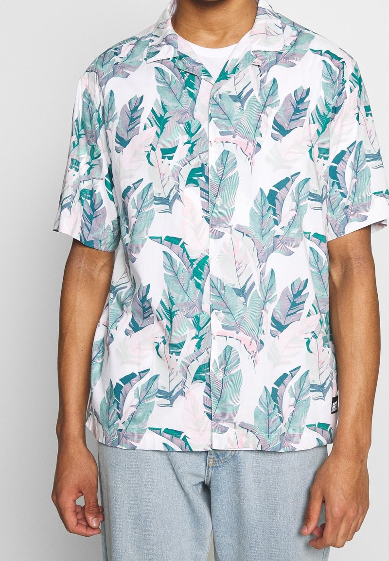 Kortärmad skjorta i lätt material, med vit bakgrund och gröna och rosa bladmönster. Klassisk krage och knappframsidan.
