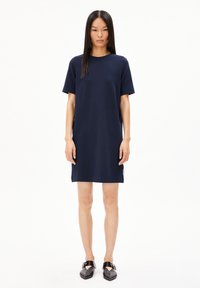 Robe bleu marine à manches courtes avec une coupe décontractée, fabriquée dans un tissu lisse. Présente un col rond et un subtil détail d'ouverture sur le côté.