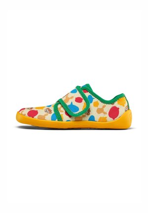 Kinderschuhe mit einem beigen Obermaterial aus Stoff, das mit mehrfarbigen Punkten und Tiermustern verziert ist. Grüne Besätze und gelbe Gummisohle. Klettverschluss.