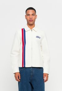 White zip-up jacket with blue and red vertical stripes; features an embroidered "Ford" logo; made of smooth fabric, collared design.