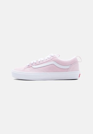 Niskie sneakersy z jasnoróżowego zamszu z białym falistym paskiem, sznurowadłami i białą gumową podeszwą na jednolitym tle.