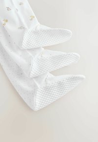 Chaussettes pour bébé en coton blanc avec des grips en caoutchouc texturés, ornées de motifs d'animaux aux couleurs douces et d'un design à pois sur la zone du pied.