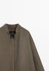 Green wool blend coat with a round collar, front pleat detail, and clean lines, featuring a subtle texture and no visible fastenings.