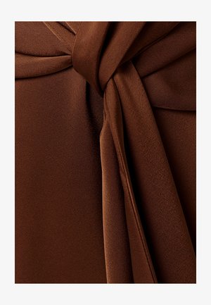 Glat brunt stof bundet i en løs knude med synlige folder og blød tekstur.