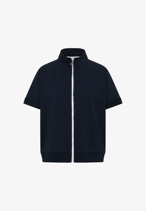 Veste bleu marine à manches courtes avec col montant et fermeture éclair blanche à l’avant, avec poches avant et ourlet et poignets côtelés.