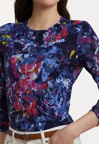 Strikket langermet topp med et blomsterdesign i blå, rosa og gule nyanser, med rund hals og ribbestrikkede mansjetter.