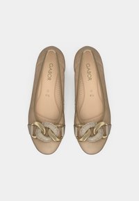 Beige skinn ballettsko med rund tå, med en dekorativ gull- og tau-detalj foran. Myk innerfôr.