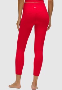 Leggings rojos de cintura alta hechos de tela elástica, con una textura suave y un pequeño detalle de logo en la parte posterior de la cinturilla.