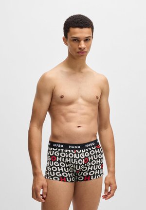 Sorte boxer briefs med hvid og rød "HUGO" logo tryk, elastisk talje, tætsiddende pasform og glat stoftekstur.