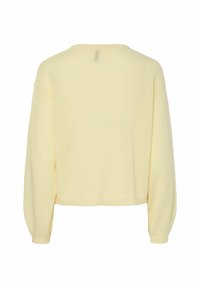 Rumena skrajšana jopica z dolgimi, rahlo napihnjenimi rokavi, izdelana iz mehke pletene tkanine, z okroglo izrezano vratno odprtino in preprostim dizajnom.