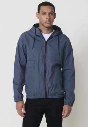 Hooded Windbreaker-Jacke in Dunkelgrau, mit einem Frontreißverschluss, elastischen Bündchen und seitlichen Taschen. Leichtes Gewebe mit einer glatten Textur.