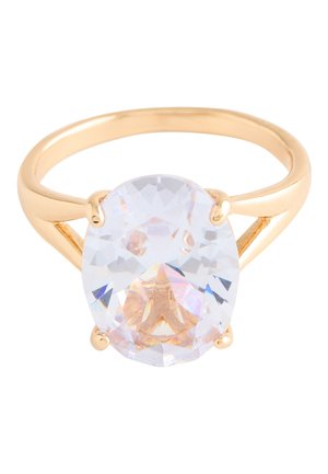 Gold ring with a large oval clear gemstone held by four prongs on a simple polished band.