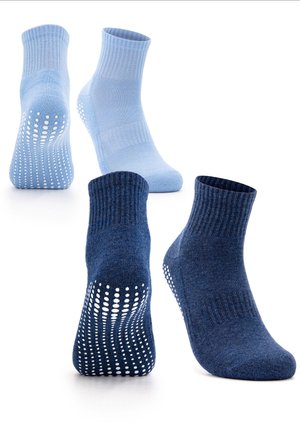Two pairs of ankle socks, one light blue and one dark blue, each featuring white non-slip grips on the soles.