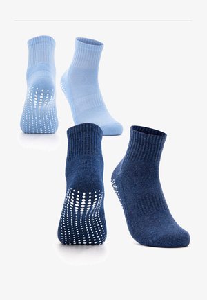 Two pairs of ankle socks, one light blue and one dark blue, each featuring white non-slip grips on the soles.