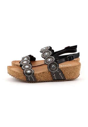 Sandali neri con decorativi paillettes rotonde, suola in sughero a zeppa, cinturino regolabile e una soletta liscia e testurizzata.