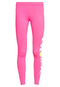 Jasnoróżowe legginsy wykonane z elastycznego materiału, z nadrukiem w formie uśmiechniętej buźki i stylizowanym tekstem po jednej stronie.
