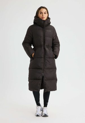 Lange zwarte pufferjas met een ritssluiting aan de voorkant, hoge kraag en een aansluitende taille. Voorzien van een quilted ontwerp en twee voorzakken.