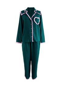 Grönt pyjamaset med långärmad tröja och byxor, med rosa rynkad kant och ett hjärtdesign på tröjan. Mjukt tyg.