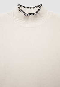 Beige gerippter Rollkragenpullover mit schwarzem Rüschensaum am Ausschnitt. Der Stoff scheint weich mit einer glatten Textur und einem taillierten Design zu sein.