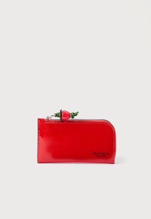 Portefeuille rectangulaire rouge avec fermeture éclair et un petit pendentif en forme de fraise attaché au curseur, sur un fond uni.