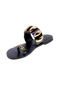 Sandal nera piatta con una fascia larga decorata con accenti sferici in tono oro e un passante per le dita. Texture liscia e design minimalista.