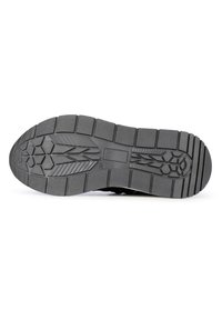Semelle de chaussure en caoutchouc noir avec un motif de semelle complexe, présentant des designs hexagonaux et linéaires, surface texturée pour l'adhérence et la durabilité.