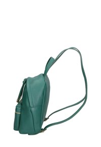 Zaino in pelle verde con finitura testurizzata, tasca frontale con zip e spallacci regolabili. Silhouette laterale che evidenzia il design compatto.