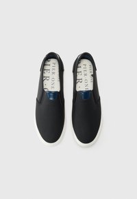 Crne slip-on cipele s teksturiranim gornjim dijelom, s mornarskoplavim naglaskom na peti i bijelim gumiranim potplatima. Obložen unutarnji dio s otisnutim logotipom.
