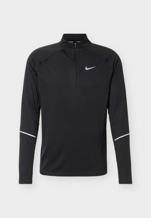 Black long-sleeve athletic top with quarter zipper, reflective Nike logo on chest, and reflective stripes on forearms.