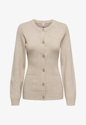 Bežinis megztinis, pagamintas iš minkštos mezgimo medžiagos. Svarbiausi bruožai: apvalus iškirpimas, sagčių užsegimas, dvi priekinės kišenės ir banguoti rankogaliai bei apatinė dalis.