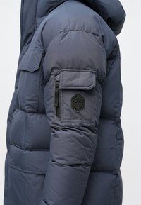 Ναυτικό μπουφάν με φανελάκι, διαθέτει τσέπη με φερμουάρ και εσωτερική επιφάνεια με εξαγωνική στάμπα στο αριστερό μανίκι; ομαλή υφή, θερμική σχεδίαση.