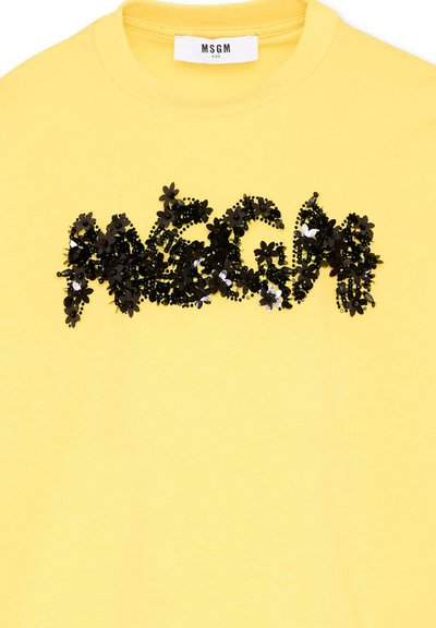 T-shirt jaune enfant avec col rond et étiquette MSGM Kids, ornée de motifs floraux noirs et de perles sur la poitrine.