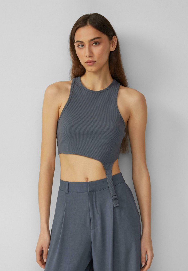Šedý žebrovaný crop top s vysokým výstřihem a bočním výřezem, s detailem pásku v pase. Hladká textura, přiléhavý design.