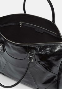 Schwarze Ledertasche mit doppelten Griffen, offener Oberseite mit Reißverschluss, die ein geräumiges Innenleben mit einer inneren Reißverschlusstasche und stoffbezogener Innenauskleidung enthüllt.