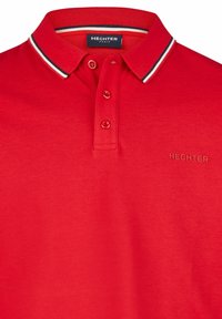 Rode polo met een kraag voorzien van zwart-witte strepen. Drie-knopen sluiting en geborduurd "HECHTER" logo in metallic goud.