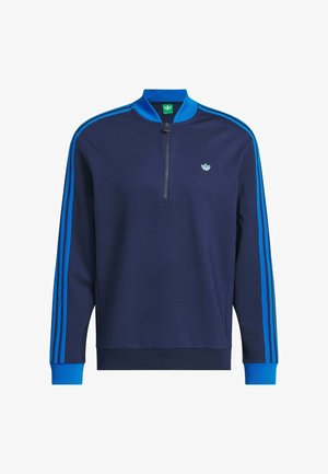 Tmavě modrá mikina s kapsou na zip u krku, vyrobená z měkké látky, s třemi modrými pruhy podél rukávů a malým logem na hrudi.