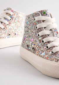 Sneakers glitterate con design a collo alto; copertura glitterata colorata, lacci bianchi, occhielli metallici e suola in gomma texturizzata.