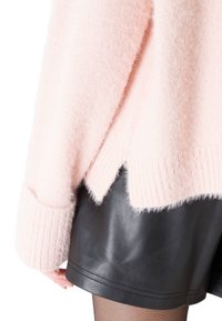 Weicher, pinker, flauschiger Pullover mit Rippb�ündchen und -saum, der hinten einen Schlitz hat, getragen über schwarzen Leder-Shorts.