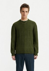 Dunkelgrüner Kabelstrick-Pullover mit rundem Halsausschnitt, Rippb�ündchen und Saum. Strukturierter, gemütlicher Stoff mit auffälligem Zopfmuster.