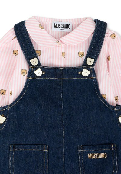 Chemise bébé rayée rose et blanche avec des visages d'oursons sous une salopette en denim foncé ornée de boutons en forme d'ours et du logo Moschino.
