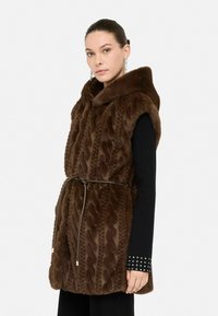 Gilet in finta pelliccia marrone con motivo a treccia, cappuccio e cintura regolabile. Presenta maniche lunghe e tessuto nero sotto.