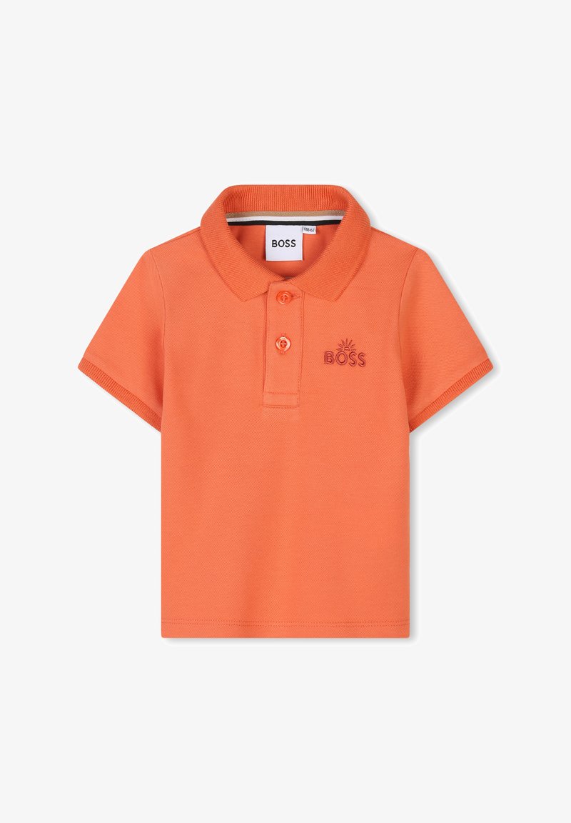 Polo orange en tissu texturé, avec un col, trois boutons et un petit logo brodé sur la poitrine.