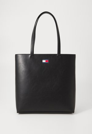 Czarna skórzana torba typu tote z dwoma długimi uchwytami i małym prostokątnym logo Tommy Jeans na środku górnej części z przodu.