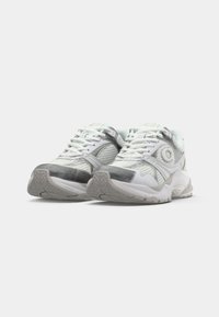 Witte sportieve sneakers met metallic zilveren accenten, meshpanelen, textuurzolen en platte veters. Ronde neus en ondersteunend ontwerp.